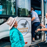 A Boobook Explore host greeting guests as they board a 4WD bus